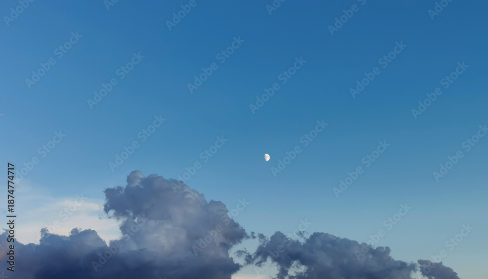 Obraz premium Luna di giorno nel cielo sopra le nuvole