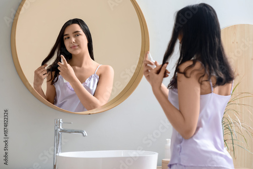 Young woman applying hair s...