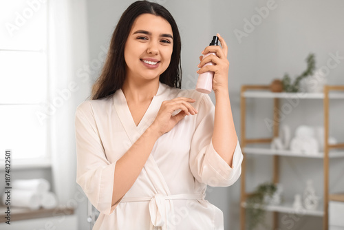 Young woman with hair spray...