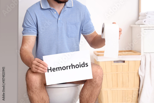 Young man holding paper wit...