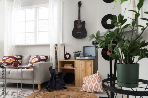 фотографія Interior of living room with sofa, guitars and record player