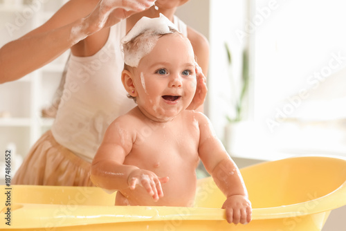 Young mother bathing her ba...