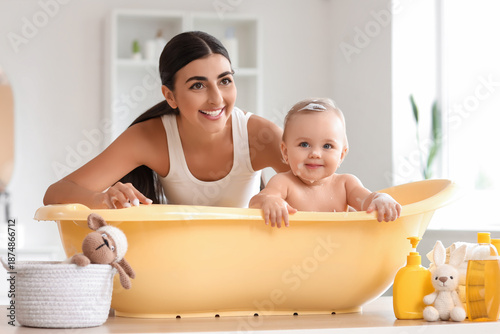 Young mother bathing her ba...