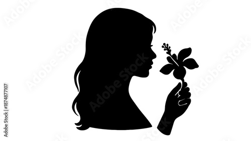 A black silhouette of a girl smelling a flower in her hand