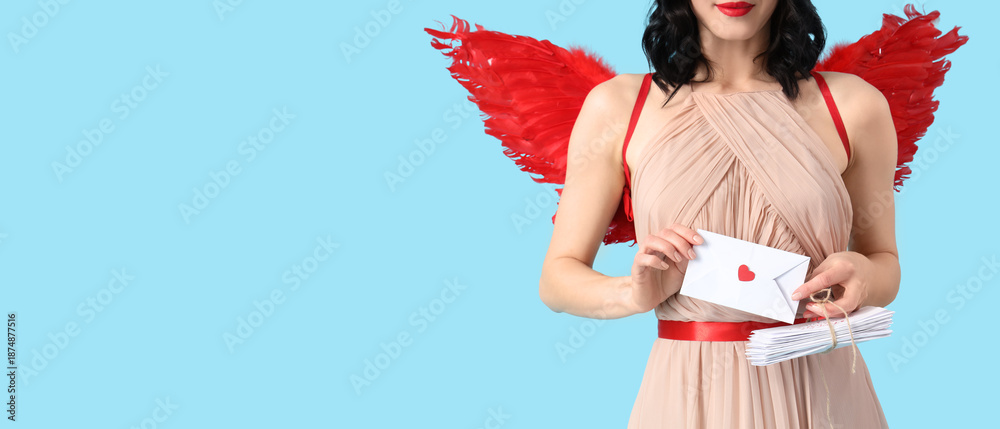 Fototapeta premium Beautiful young woman dressed as cupid holding letters on blue background with space for text. Valentine's Day celebration