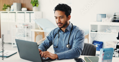 фотографія Man, doctor and reading with laptop in hospital for research, medical report and confirm surgery
