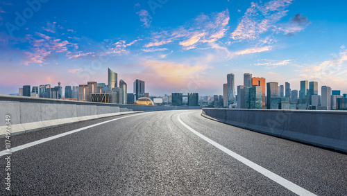 Empty asphalt highway road and city skyline with modern buildings at sunrise in Hangzhou