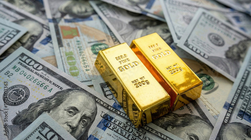 Two fine gold bars rest on a pile of US one hundred dollar bills.