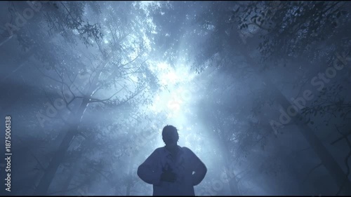Man Reaching Towards Light in Misty Forest, Hopeful Expression