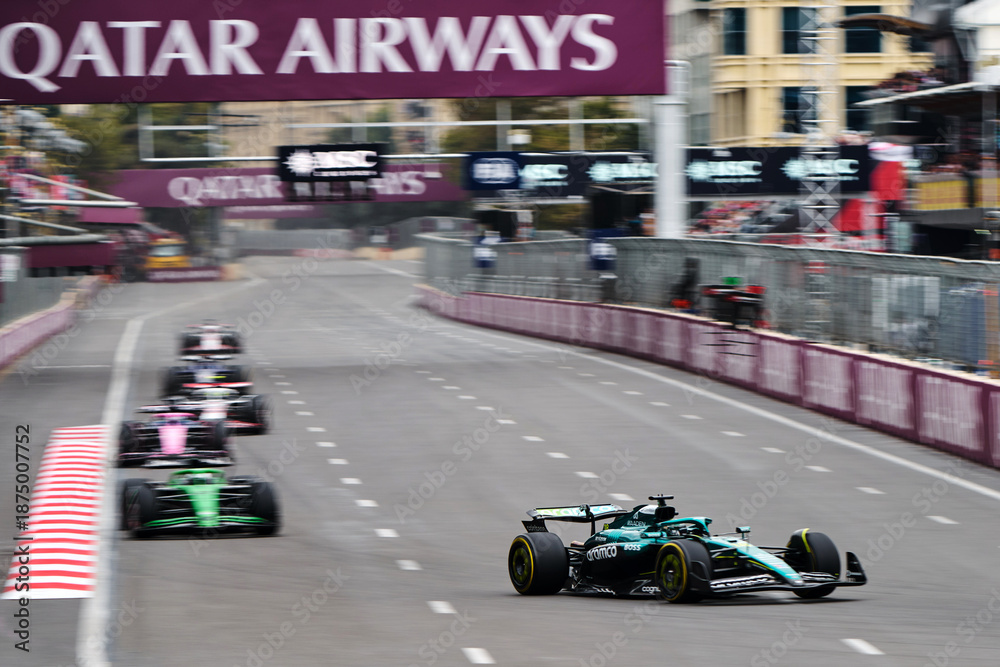 Fototapeta premium BAKU, AZERBAIJAN - SEPTEMBER 21, 2025: Lance Stroll in the Aston Martin Aramco AMR25 leads a group of Formula 1 cars during the Azerbaijan Grand Prix