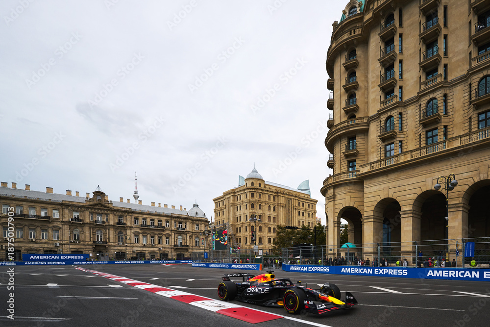 Fototapeta premium BAKU, AZERBAIJAN - SEPTEMBER 21, 2025: Max Verstappen drives the Oracle Red Bull Racing RB21 past the historic architecture of Baku during the Formula 1 Azerbaijan Grand Prix