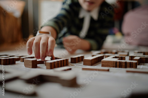 Bilde på lerret Caucasian child building architectural model with wooden blocks, demonstrating a
