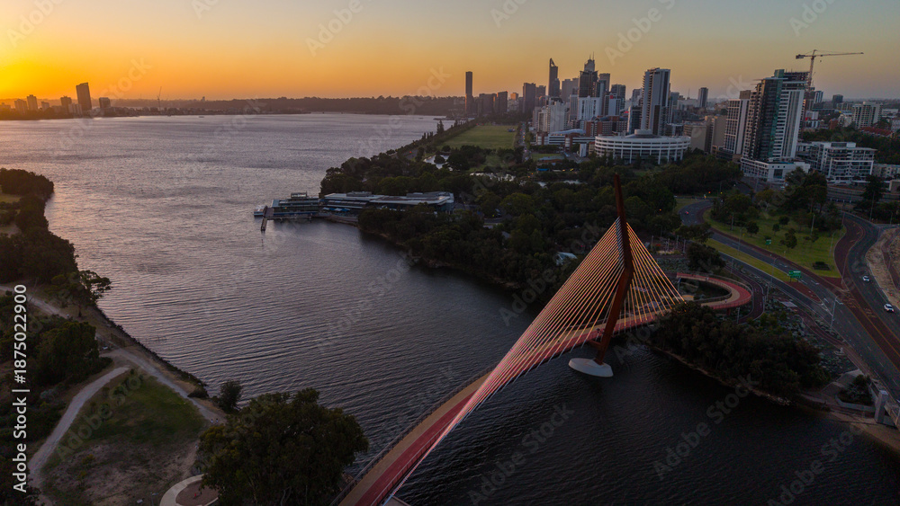 Fototapeta premium Aerial view of Perth city skyline with Boorloo bridge lit up connecting Heirisson island with walking and cycling path along the Swan river
