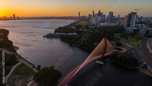 Aerial view of Perth city skyline with Boorloo bridge lit up connecting Heirisson island with walking and cycling path along the Swan river