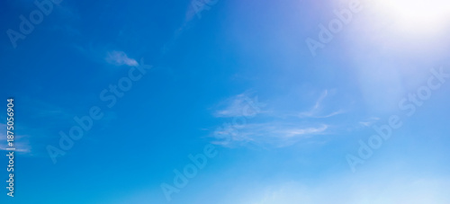 Vászonkép Clear blue sky with wispy clouds and bright sunlight in upper corner, gradient sky tones and natural cloud texture for weather background, daylight atmosphere and outdoor nature environment visuals