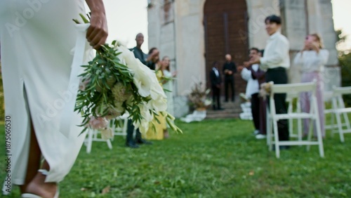Tableau sur toile The bride walks past the guests to the groom waiting for her near the church, cl