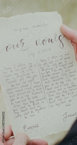 Принти на полотні A sheet with a handwritten vow in the groom's hands at an outdoor wedding