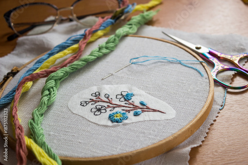 Fotografía Hand embroidery of blue forget-me-not flower at an embroiderer’s workspace