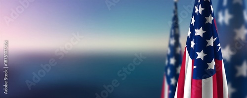 American flag waving against hazy mountain landscape at sunrise