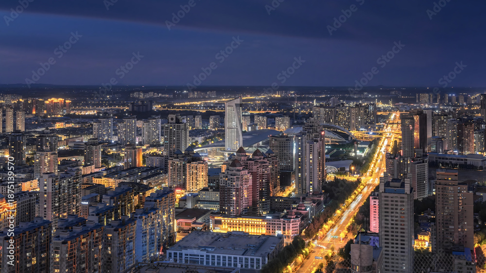 Obraz premium Illuminated Urban Cityscape at Dusk with Glowing Streets and Warm Building Lights