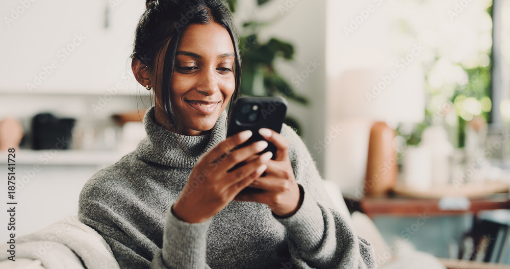 Fototapeta premium Phone, smile and woman on sofa in home with texting, social media or networking on mobile app. Happy, technology and female person with cellphone for chatting, contact or communication in living room