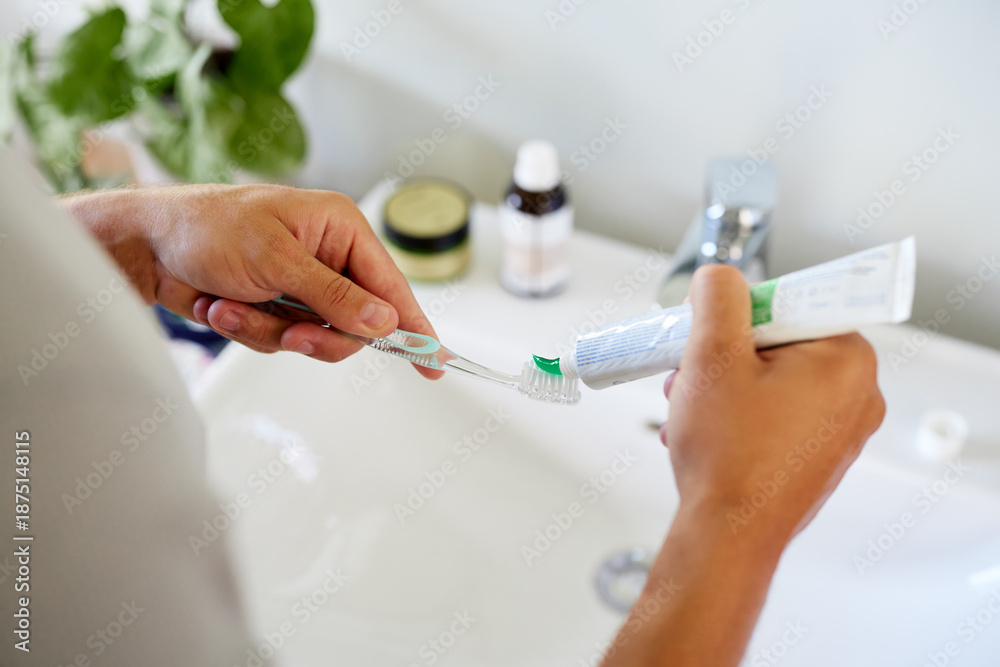 Obraz premium Man applying toothpaste on brush