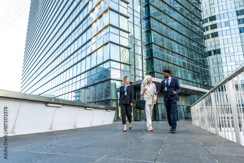 Valokuva Diverse business team walking and discussing outside modern office building
