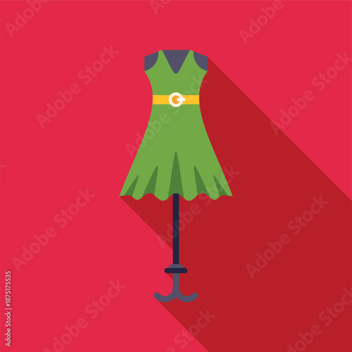 Green dress on a mannequin with a yellow belt, casting a long shadow