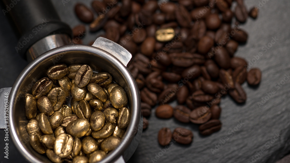 Fototapeta premium Top view of golden coffee beans filled in an espresso portafilter, surrounded by regular roasted beans on a dark background.