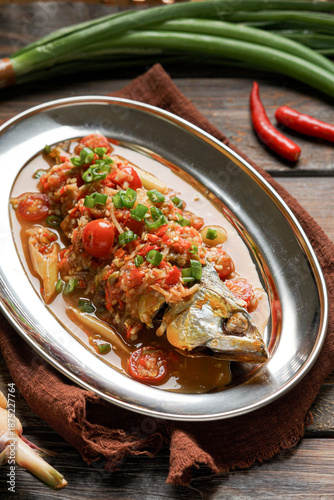 Ikan Goreng Air Asam is a traditional Malay dish featuring crispy fried fish served with fresh tamarind based dipping sauce mixed with chili onion and herbs offering a refreshing balance of sour spicy