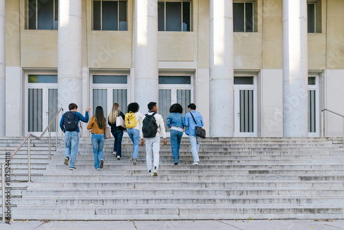 Vászonkép Group of diverse college students with backpacks walking up campus stairs toward