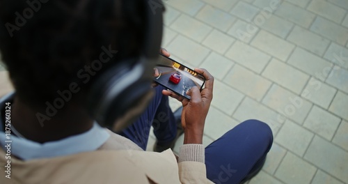 Mobile phone with online game in male hands