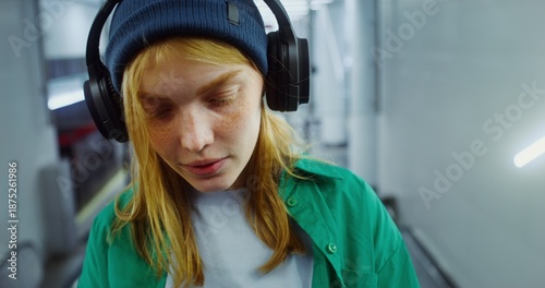 Woman in headphones playing online game on smartphone