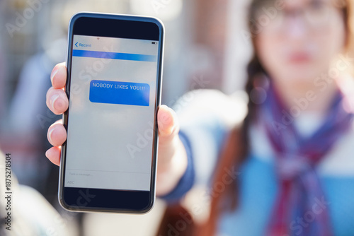 Photos Hand, phone screen and cyber bullying at college with text message, stalker or notification at campus