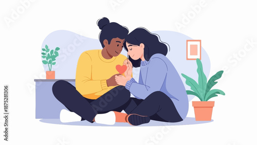 Two individuals, in a cozy indoor setting, share a tender moment, holding a small heart