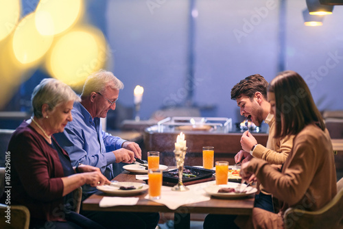 Family enjoys iftar meal in a restaurant during Ramadan with decorations and warm lighting in the background