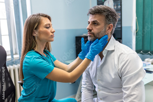 Obraz na płótnie Professional female doctor performing a physical neck examination on a male patient in a clinic
