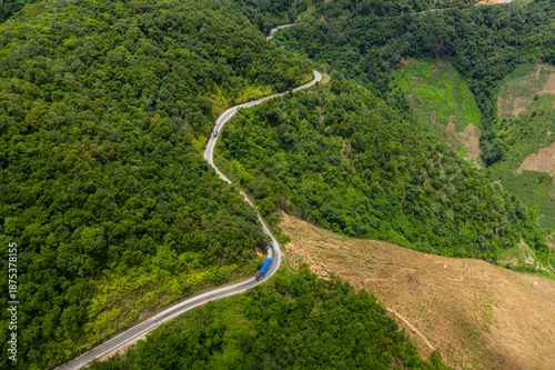 Foto A serpentine mountain road curves through dense green forest and open hillside in the highland region between Phou Khoun and Luang Prabang, Laos