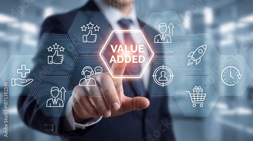 Businessman interacting with virtual interface displaying value added concepts and icons in office setting with futuristic elements