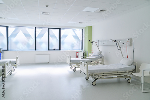 Tableau sur toile Bright and clean hospital ward with empty beds and large windows during daytime