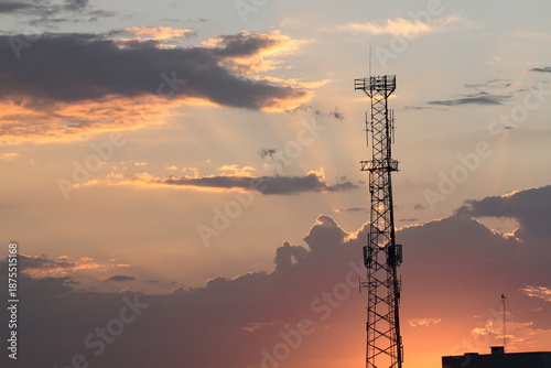 Communications antenna at sunset in the city