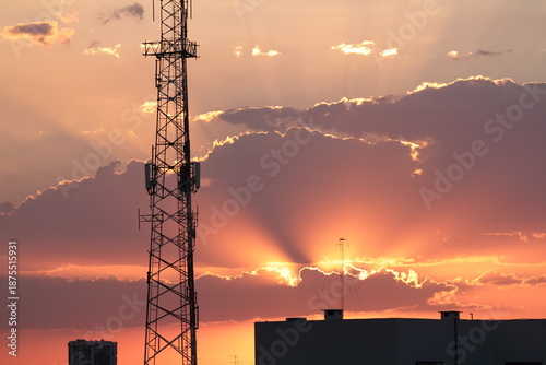 Communications antenna at sunset in the city