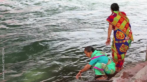 Two senior women perform a holy bath in the Ganga River at Haridwar, marking the spiritual beginning of their Char Dham Yatra with faith, devotion, and ritual cleansing.