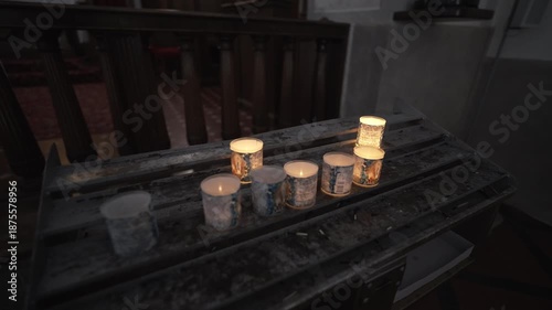 Lit Votive Candles on Metal Stand Inside Church With Soft Light