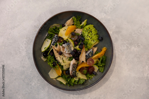 Fish and fruit salad on a marble floor.