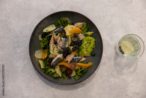 Fish and fruit salad on a marble floor.