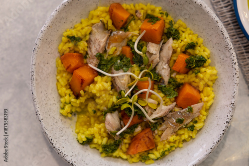 Fish, rice, and carrot dish on a marble floor.