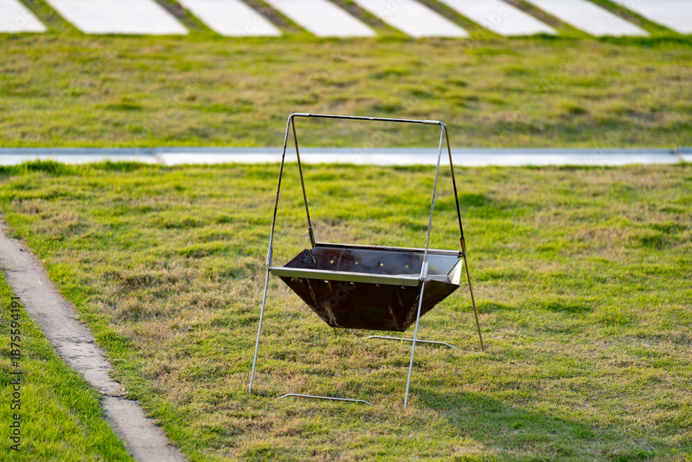 Obraz premium Grill stand on green lawn, ready for use