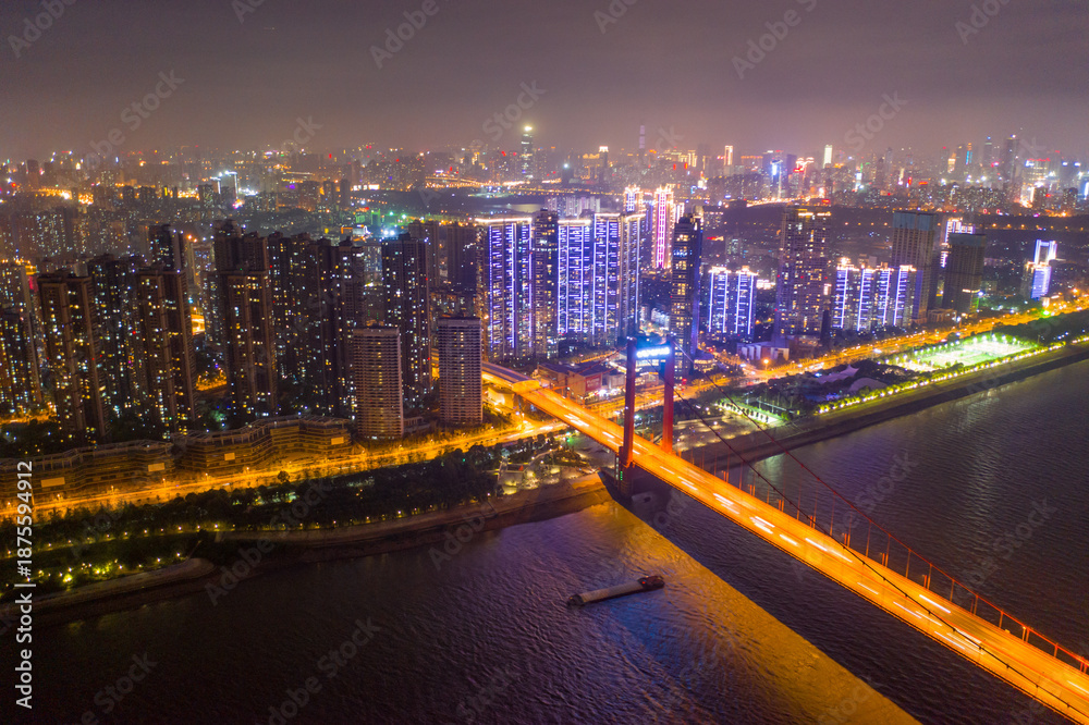 Fototapeta premium Aerial Night City Scene with Sparkling Rivers and Illuminated Bridge