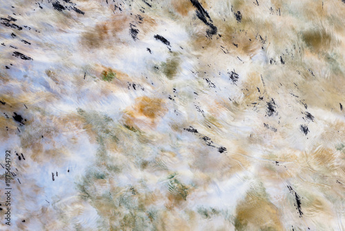 Long exposure of moving water, churning and flowing, surface highlights, impressionistic blurred effect. 